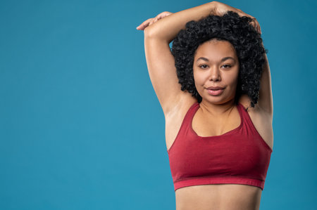 Cute young woman in red top having a workoutの写真素材