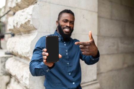 Bearded young dark-skinned man with a phoneの写真素材