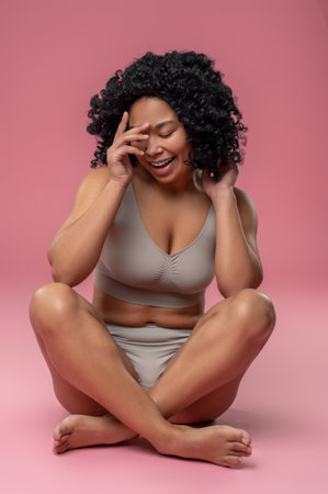 Smiling contented woman on a pink backgroundの写真素材