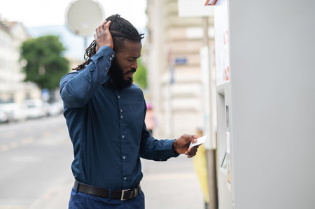 African american man retrieving money from ATMの写真素材
