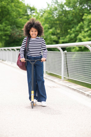 Happy kid riding on scooter, playing in open air on summer day, outdoor activity, kid lifestyle.の写真素材