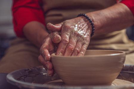 Ceramic plate on a potters wheel, ceramists hands.の写真素材