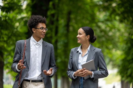 Colleagues walking in the park during the break and discussing business issues