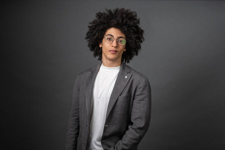 Young dark-haired stylish man on a grey backgroundの写真素材