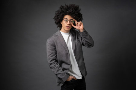 Good-looking youg businessman in eyeglasses on grey backgroundの写真素材