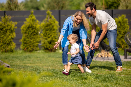 Young cute family playing with their kid in the parkの写真素材