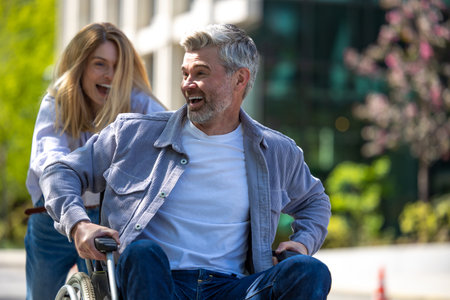 Woman with disabled husband in wheelchair running having fun while walking.の写真素材