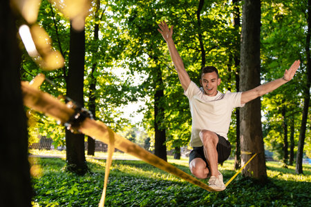 Sportsman on the rope practising slacklining and looking concentratedの写真素材