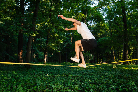 Young man in white tshirt walking on the rope