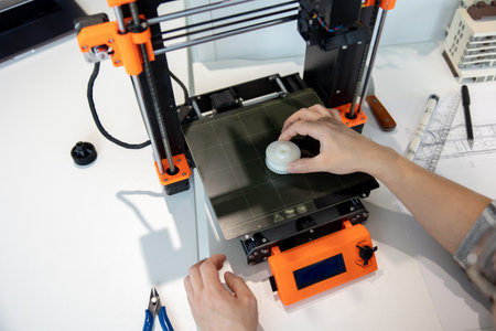 Man checking 3d printer, process of making things on 3d printer in laboratory.