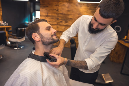 Caucasian man getting perfect shape of beard at barbershop.の写真素材