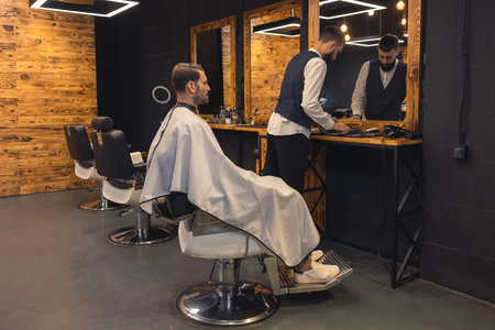 Man getting new trendy haircut or hairstyle with professional male barber.の写真素材