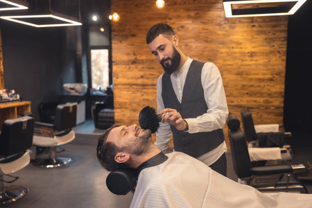 Caucasian man getting perfect shape of beard at barbershop.の写真素材