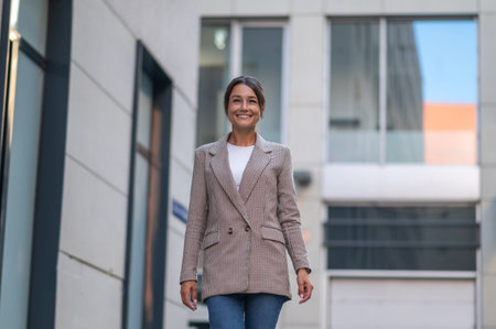 Beautiful business woman in suit near modern office building.の写真素材