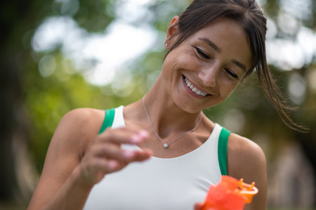 Smiling young woman with a bottle in hand feeling good after workout