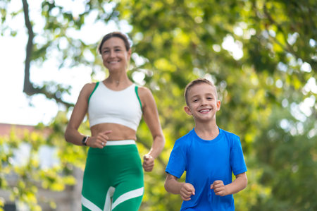 Woman and her son jogging in the park and looking contentedの写真素材
