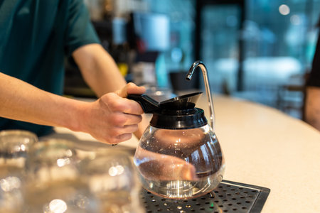 Close up picture of a woman hand holding a kettle
