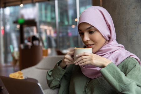 Cute woman in hijab sitting in a cafe and smiling