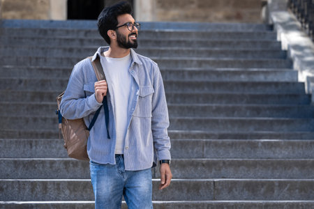 Young tall hindu man standing on the steps of an old building