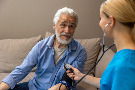 Female doctor examining senior patient measuring blood pressure.