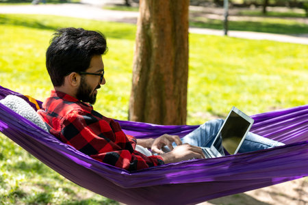 Digital nomad working on laptop in the park