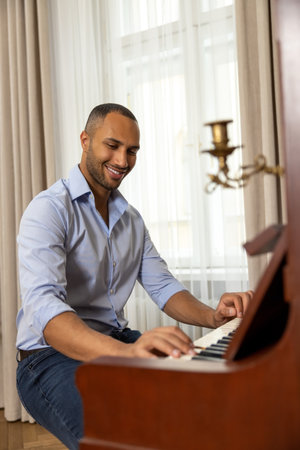 Man enjoying playing piano at home plays music on musical instrumentの写真素材