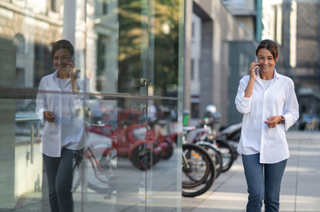 Cute woman talking on the phone and looking interestedの写真素材