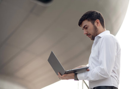 Young businessman with a phone in hand looking confident