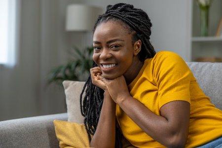 Cute african american woman in yellow tshirt smiling nicelyの写真素材