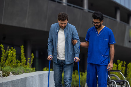 Man with sticks walking with a male nurseの写真素材