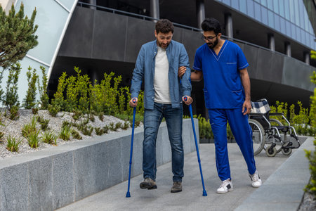 Man with sticks walking with a male nurseの写真素材