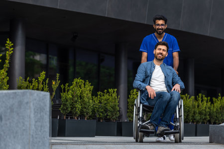 Brunette man in doctors overall carrying a wheelchair with a patientの写真素材
