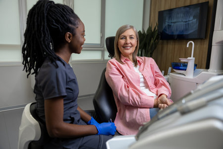 Woman dentist consulting middle aged woman in stomatology clinicの写真素材