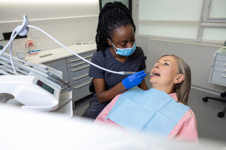 Woman visiting dentistry clinic for professional teeth treatment doctor holding instrument toolの写真素材