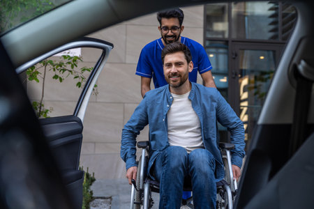 Disabled man getting on a car, male nurse helping himの写真素材