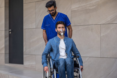 Young man in wheelchair wearing oxygen maskの写真素材