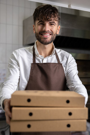 Man holding pizza boxes manages kitchen operations ensuring fast food service