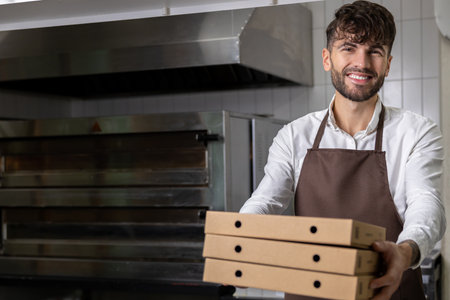 Man in apron holding pizza boxes involving preparation and delivery of tasty Italian mealsの写真素材