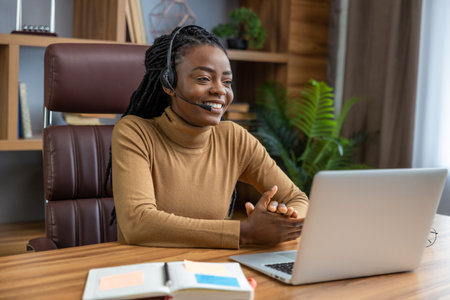 Woman with dreadlocks in headphones offers virtual training sessions using laptop
