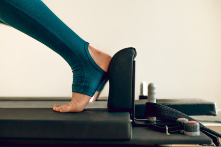 Woman fitness trainer demonstrates Pilates exercises on simulator active athletic routine