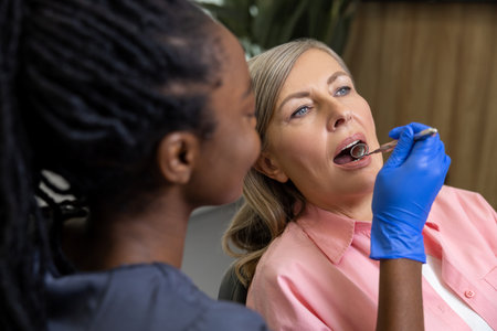 Multicultural woman dentist with female patient in stomatology clinic