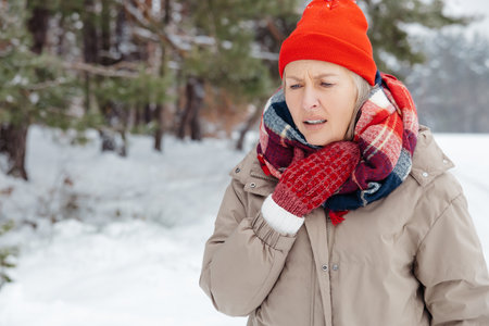 Mature woman in warm clothes having sore throat