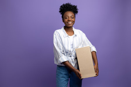 Smiling good-looking dark-skinned girl with boxes in studio