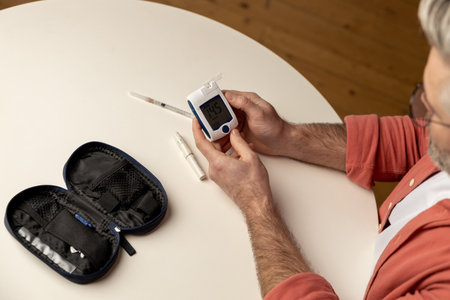 Unhealthy diabetic man checking level of sugar in blood with glucometer