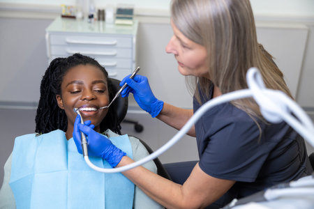 Woman dentist treating patient teeth