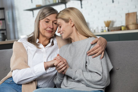 Beautiful senior woman and her adult daughter hugging and smiling