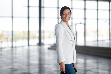 Pretty woman in white jacket in the office building