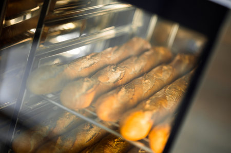 Cooking fresh crispy baguettes in oven at bakeryの写真素材