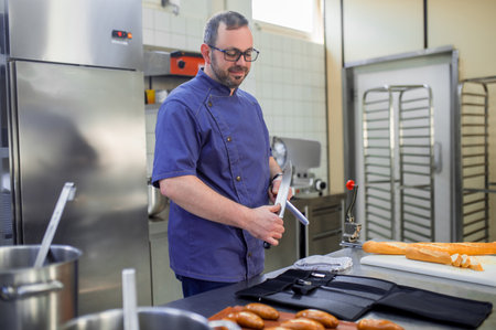 Man in eyeglasses working in the kitchen and looking involved