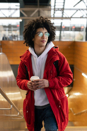 Traveler in red jacket having coffee and waiting for the train